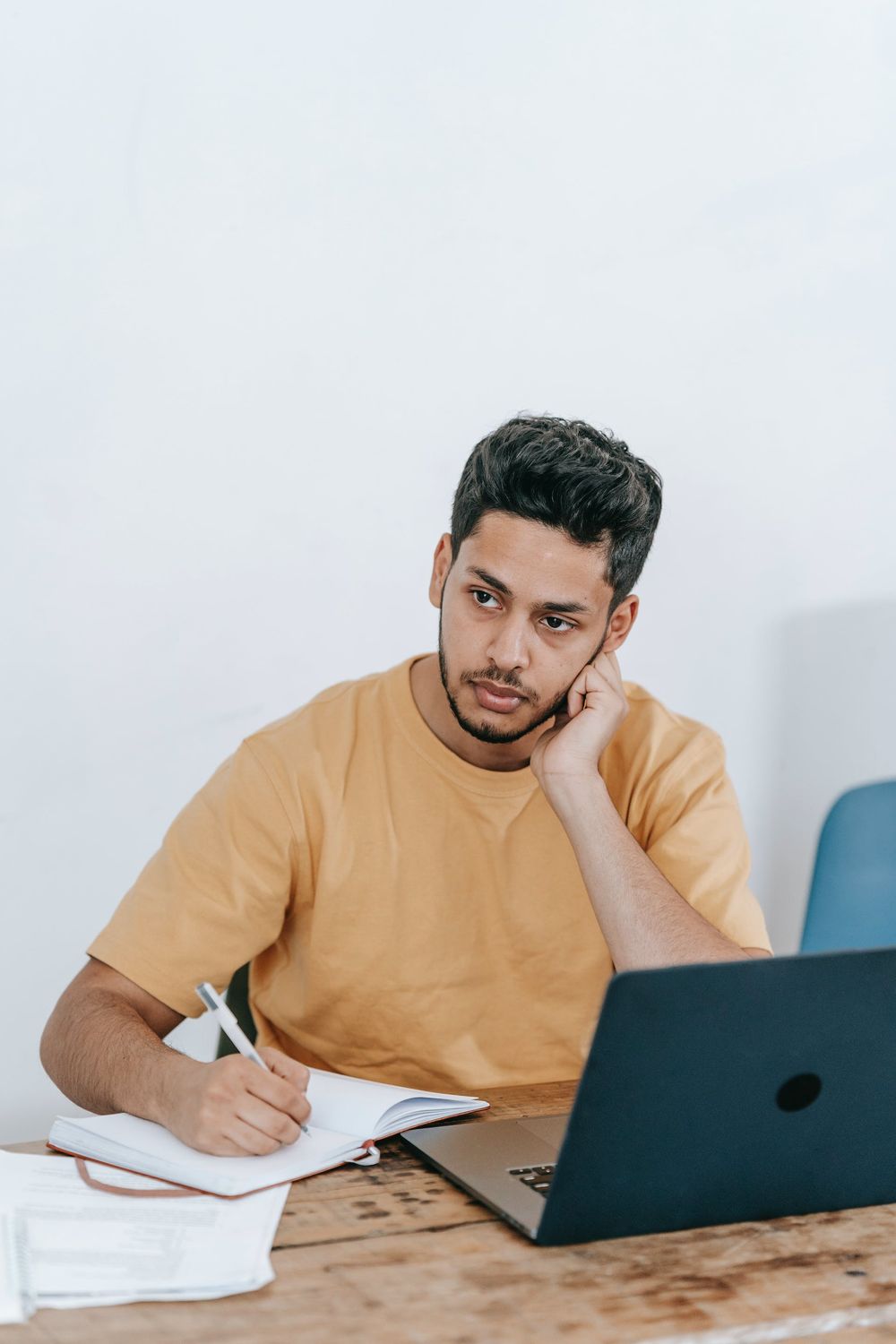 Thoughtful businessman making notes in planner